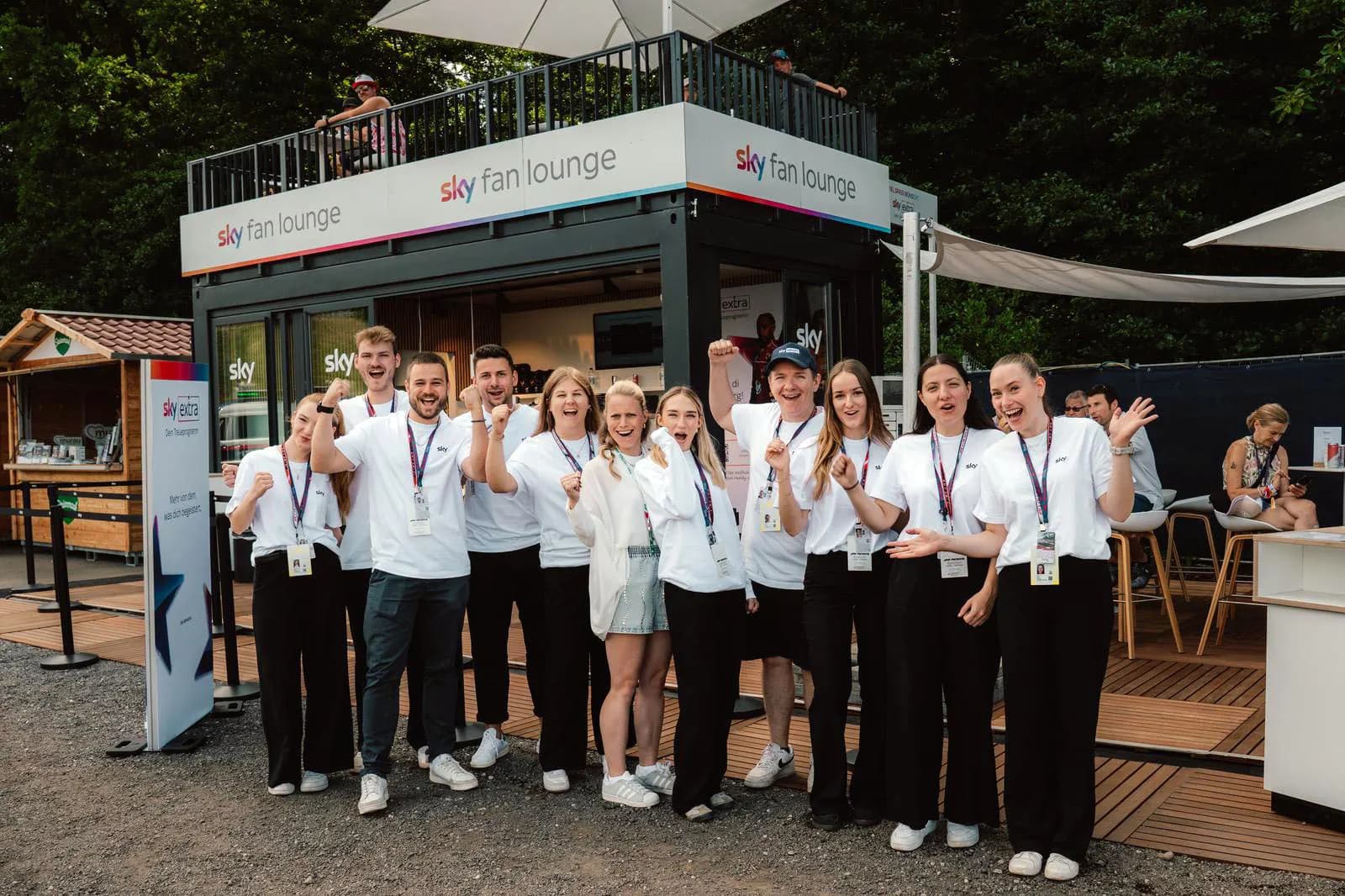 Serviceteam vor einer Eventlounge auf einem Sportgelände