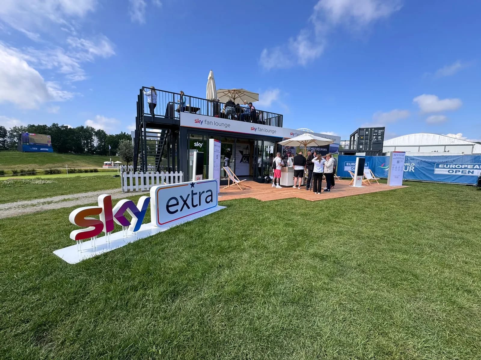 Mobile Eventlounge mit Coffee Bar am Rand eines Sportplatzes