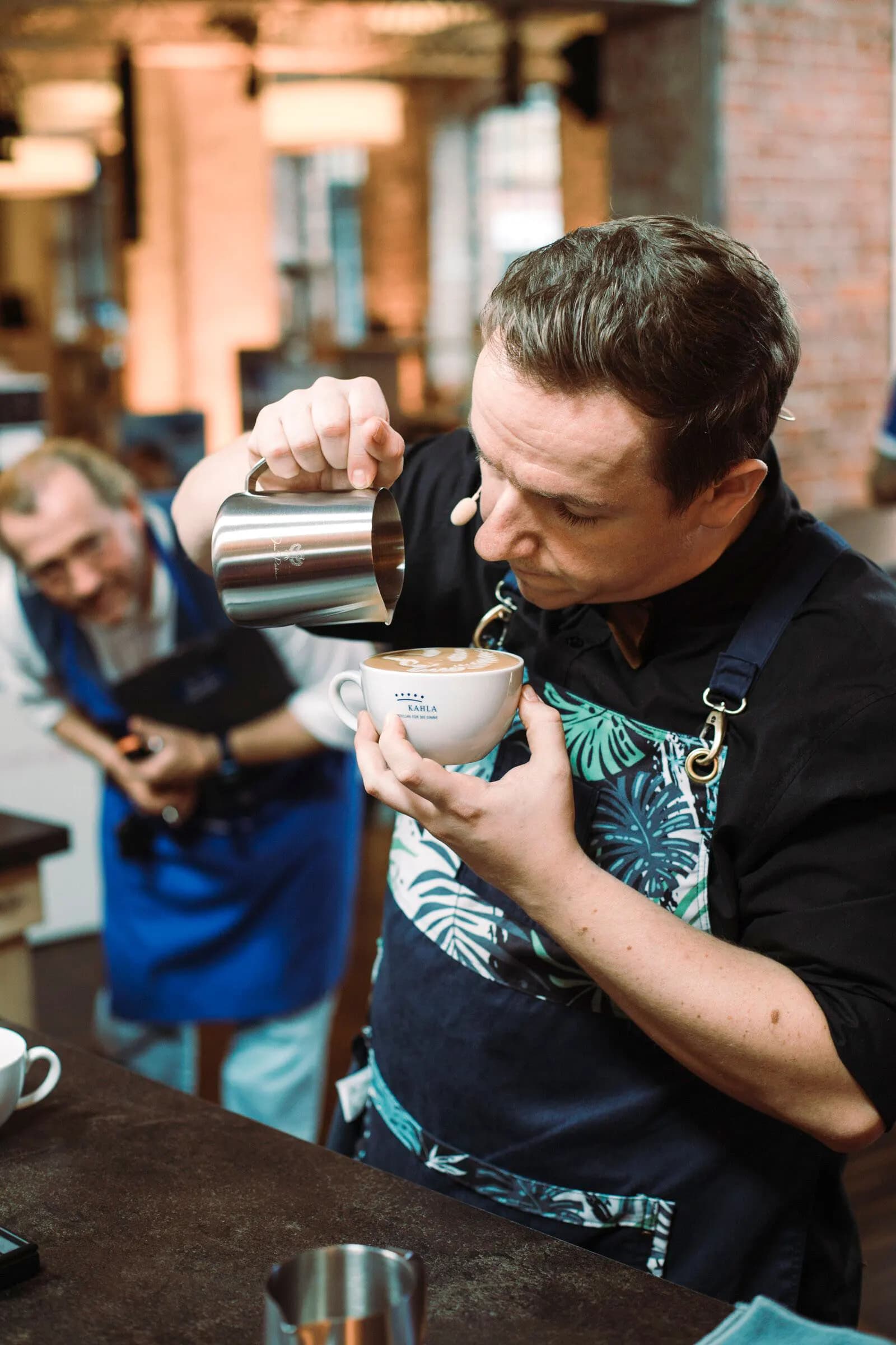 Kai Mößner gießt an der Bar Latte Art in eine Tasse
