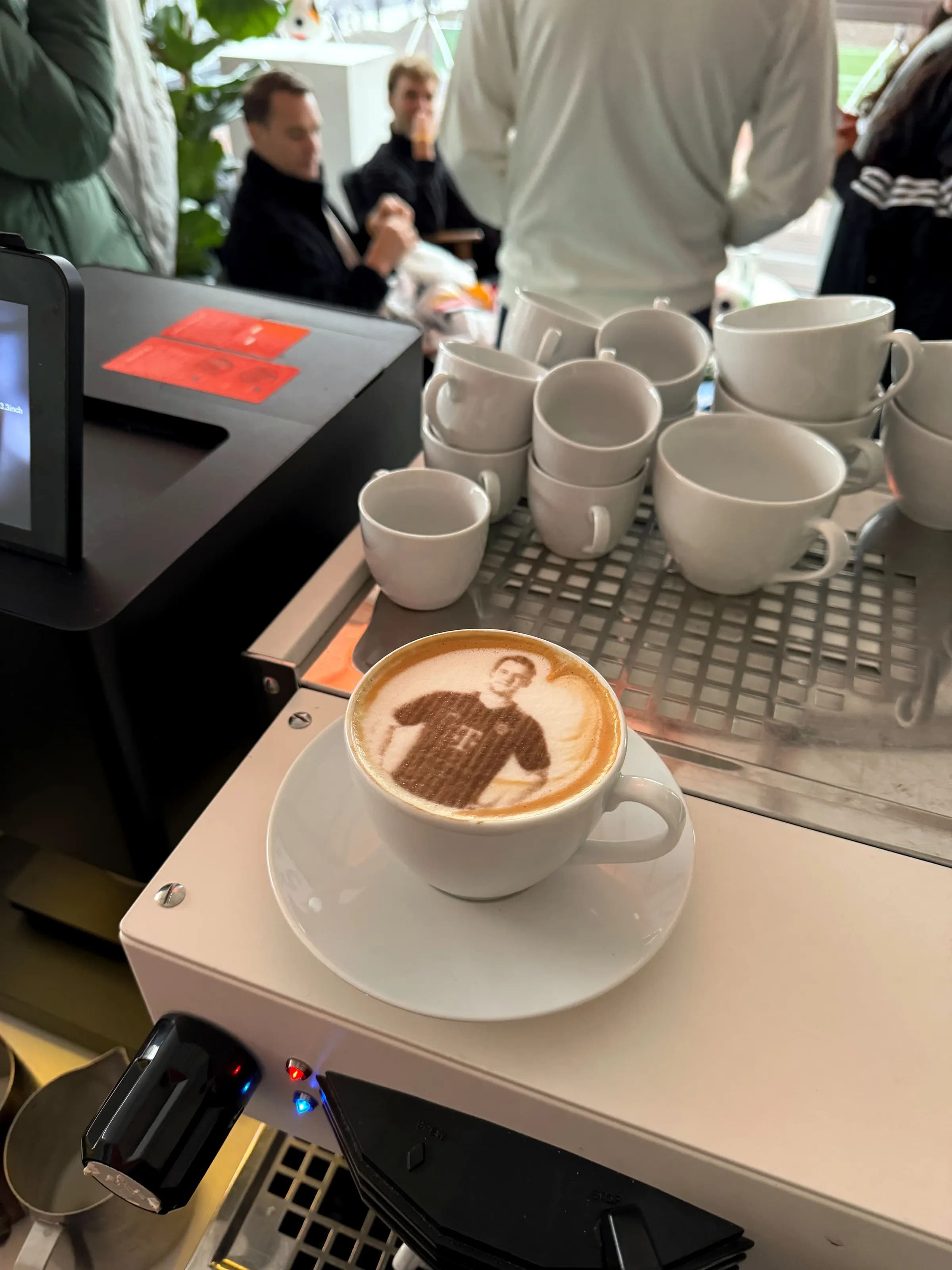 Latte-Art-Porträt in einer Tasse an der Maschine